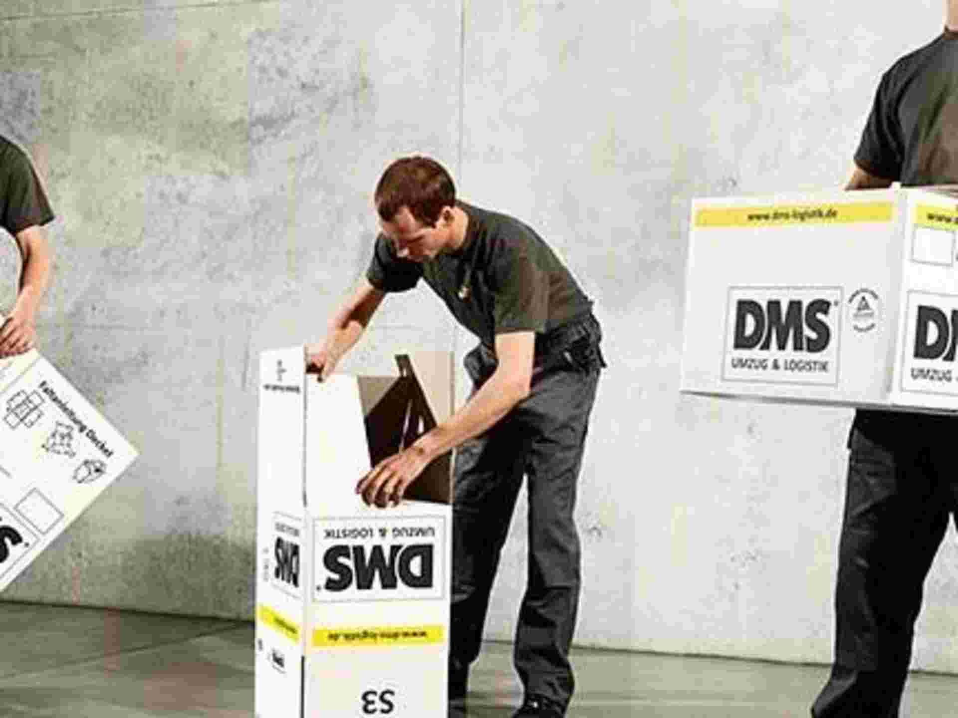 3 Umzugsfachmänner beim Aufklappen der Max Müller Umzugskartons